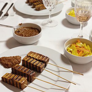 Tofu-Satay-Spieße angerichtet mit Beilagen