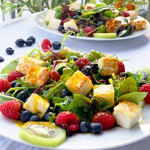 Teller mit Salat und Beeren angerichtet