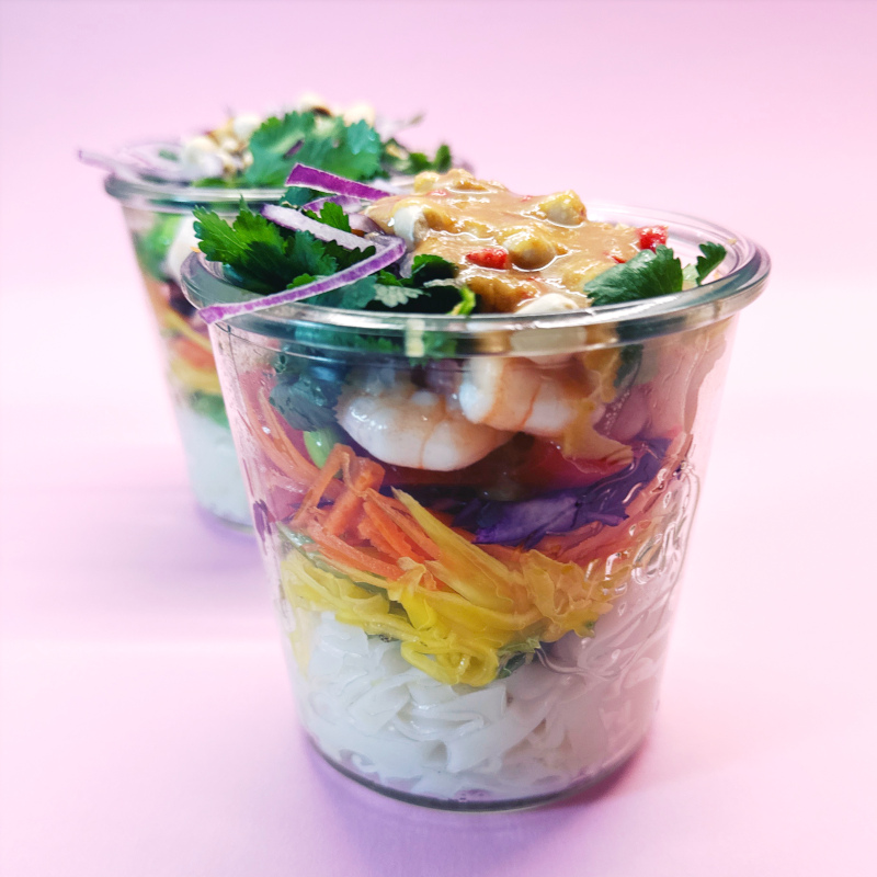 Im Glas gestapelte bunte Reisnudel-Bowl mit Thai-Style Erdnuss-Dressing