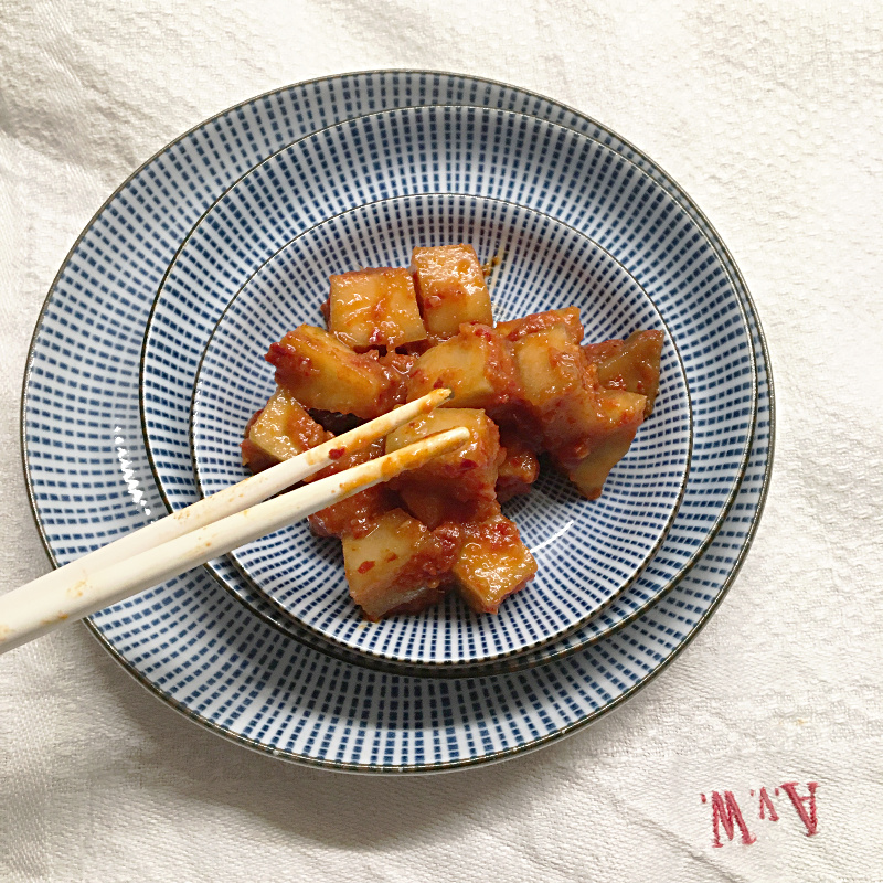 Kohlrabi-Kimchi auf verschiedenen Tellereben und Stäbchen