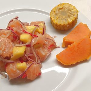 Lachs-Ceviche auf weißem Teller angerichtet
