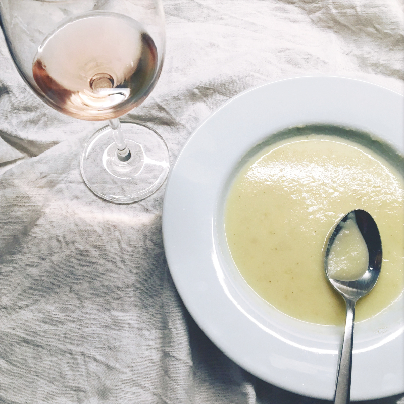 Teller mit Suppe und ein Glas Roséwein