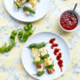 Zwei Teller mit Halloumi-Anans Grillspießen und roter Ssam-Sauce und Pimientos