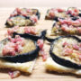 Auberginen-Blätterteig-Tarte mit Pancetta auf Holzbrett