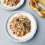 Blau-weißer Porzellanteller mit Tofu-Salat Schweizer Art mit Brezel an der Seite