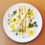 Weißer Teller mit Spargelsalat mit Ei und Miso-Sesam-Dressing
